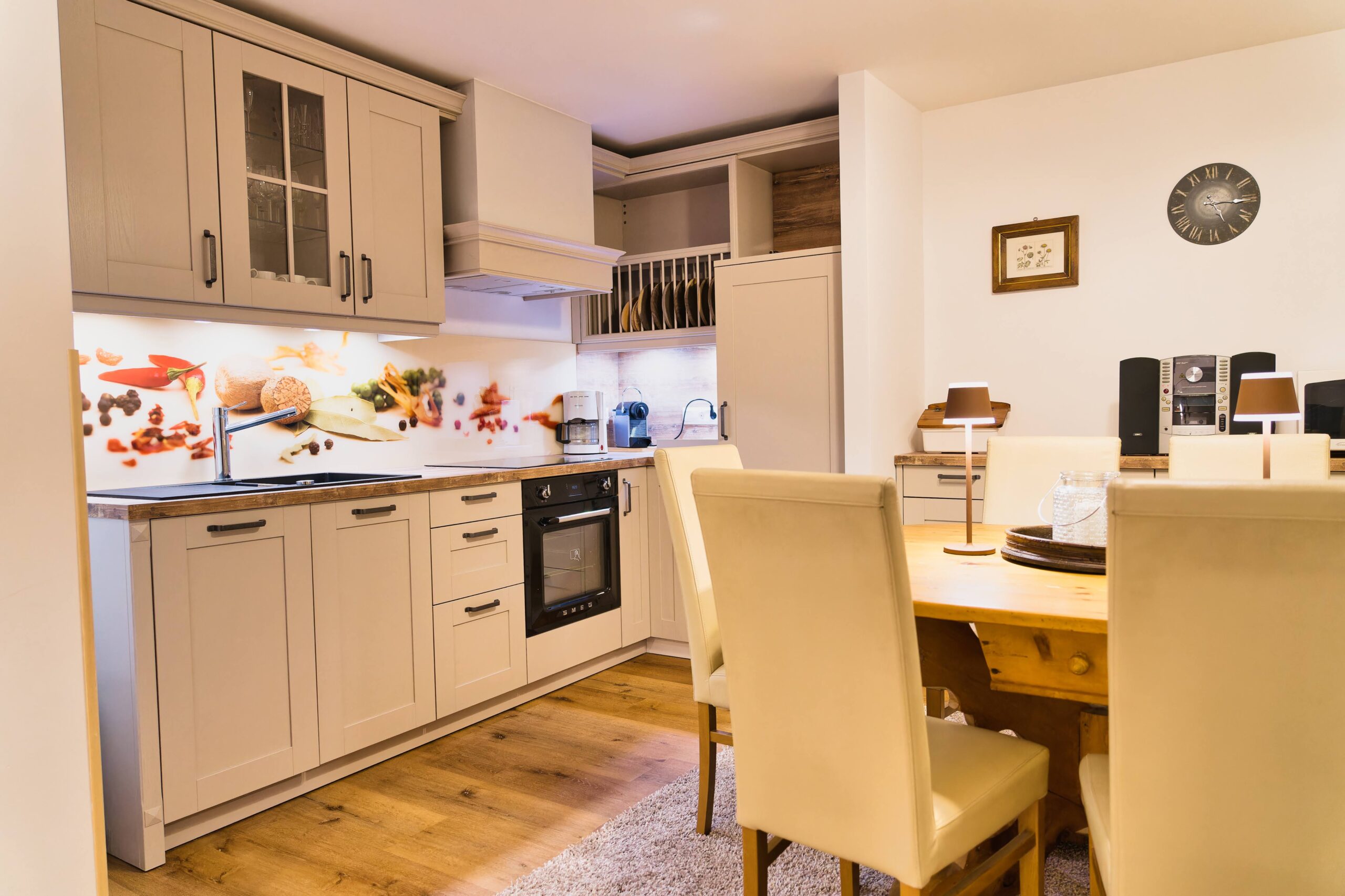 Offene, voll ausgestattete Küche mit Geschirrspüler, Herd, Kühlschrank, Kaffeemaschinen.