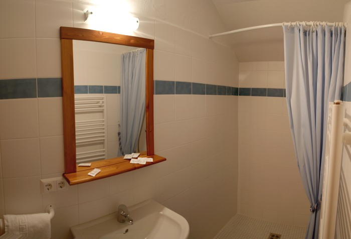 Badezimmer im Obergeschoss mit Dusche, Waschbecken und Handtuchtrockner.