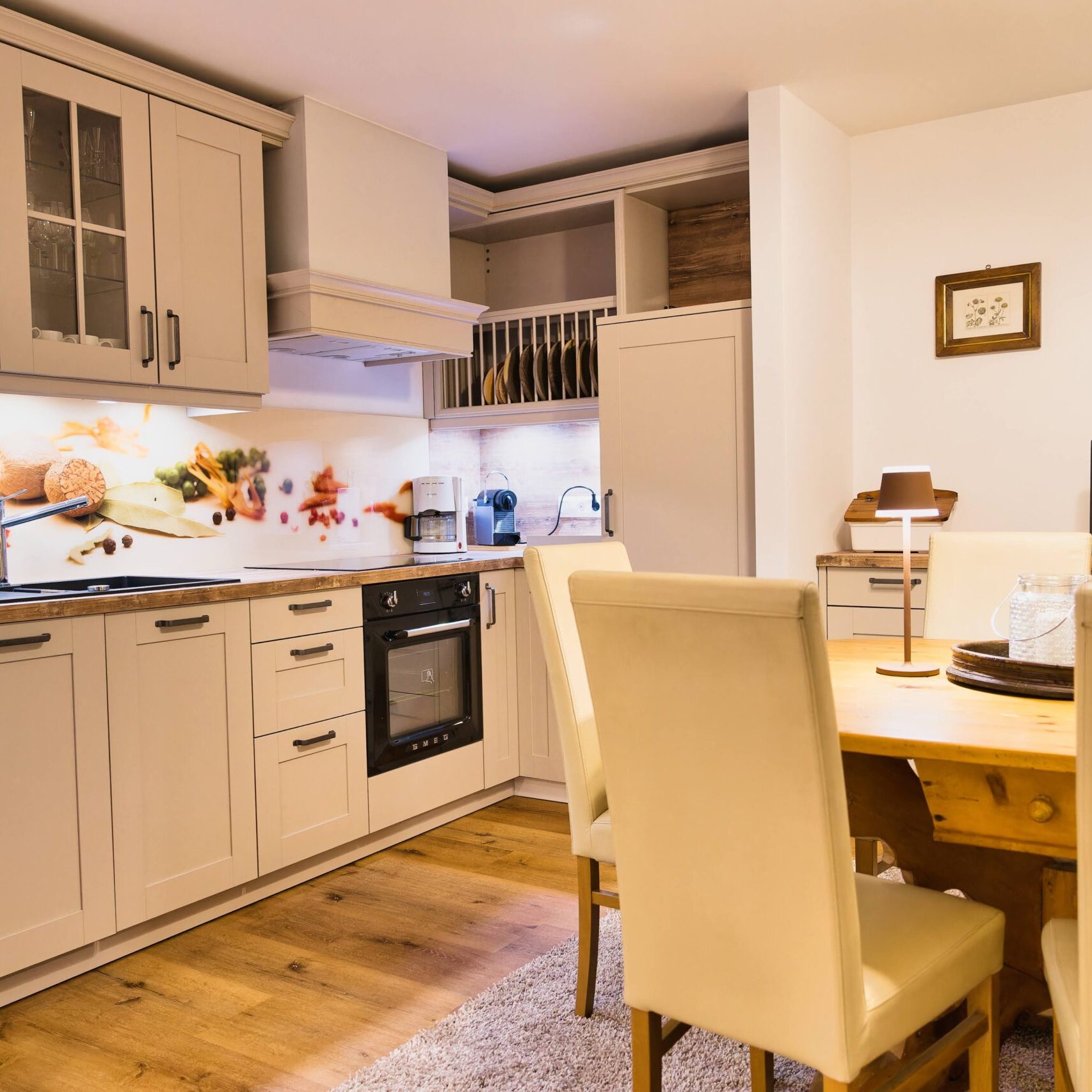 Offene, voll ausgestattete Küche mit Geschirrspüler, Herd, Kühlschrank, Kaffeemaschinen.